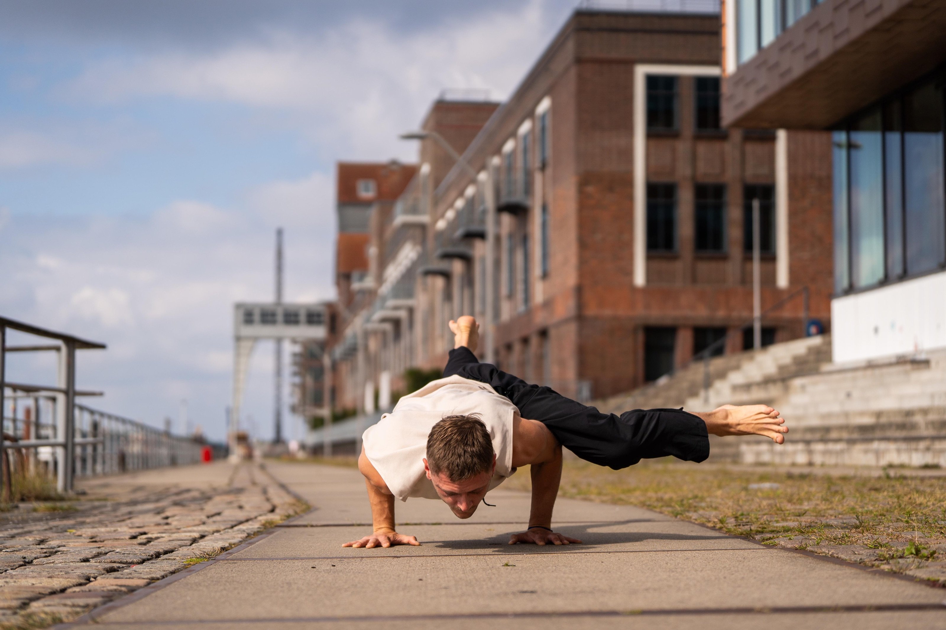 Lennart practising an arm balance on a Hamburg waterfront promenade